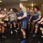 Lock Tom Donnelly is sprayed with bubbly by his team-mates inside the Otago dressing room. Photo...