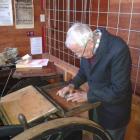 Lou Young, from the  Ferrymead Printing Society, Christchurch, locks the type for the first print...