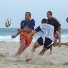 Luke Herden pops the pass for Matt Faddes (right) at St Kilda Beach as Marshall Suckling comes in...