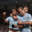 Manchester City's Carlos Tevez, left, celebrates with teammates after scoring his second goal...
