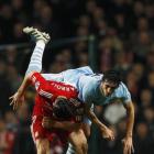 Manchester City's Stefan Savic (R) challenges Liverpool's Andy Carroll during their League Cup...