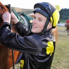 Matthew Cameron unsaddles his third winner, Vincitore, at Oamaru yesterday. Photo by Tayler Strong.