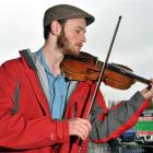 Matthew Scadden busks at the Otago Farmers Market to fundraise for a trip to London. Photos by...