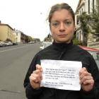 Megan Balchin displays the message she received from an angry motorist after returning to her car...