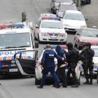 Members of the Dunedin armed offenders squad (above) arrest a man in Dundas St about 2pm...