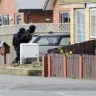 Members of the Dunedin armed offenders squad storm a house in Prince Albert Rd, St Kilda,...