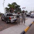 Members of the Libyan security forces stand guard close to the headquarters of the General...