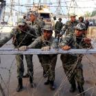 Members of the Republican Guard move barbed wire barricades to close a road leading to the...