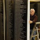 Otago Settlers Museum preparator Steve Munro helps prepare banners for an honour roll display....