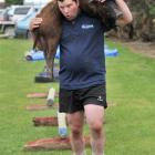 Michael Marshall, of West Otago, carries the carcass of a wild pig in the obstacle course section...