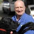 Mike Teasdale gets a cuddle from his curly coated retriever Wilson yesterday. Photo by Linda...