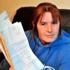 Milton process worker Danelle Byrne holds several IRD letters demanding she file an overdue GST...