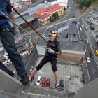 More FM Dunedin radio announcer Nicky Rennie abseils down the side of Radio Otago House with...