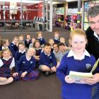 Mosgiel Rotary member Mike Lord gives the first dictionary to Nicole O'Brien (8) on Monday, while...