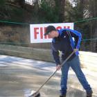 Naseby luge coach Greg Jones sweeps water off the surface of the luge track yesterday afternoon,...