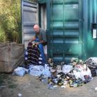 Naseby resident Bill Townsend sorts through rubbish, clothes and recyclables left outside the...