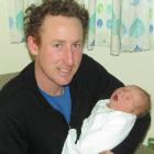 New Year baby  Finnian Toc O'Malley  relaxes in the arms  of his father, Christopher,  at  Oamaru...