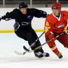 New Zealand's Andrew Cox (left) and China's Tianyu Hu compete for the ball during their ice...