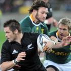 New Zealand's Richie McCaw slips the tackle of South Africa's Danie Rossouw in the International...