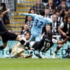 Newcastle United players tackle Manchester City's Carlos Tevez (C) as he tries to score during...