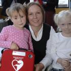 Nicci Reddy with daughters Caitlin (left) and Madison Frost with the "Heartstart" defibrillator...
