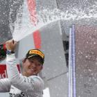 Nico Rosberg sprays champagne as he celebrates on the podium after winning the German F1 Grand...