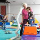 Nola Paterson helps 2-year-old Auryn Donnelly use playground equipment she constructed using...