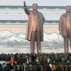 North Koreans gather in front of bronze statues of North Korea's founder Kim Il Sung (L) and late...