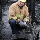 North Otago fire safety management officer Stu Ide inspects the  historic homestead destroyed by...