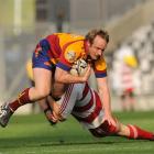 North Otago halfback Hamish McKenzie is tackled by West Coast No8 Nathan Iafeta during the...