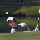 Northern Ireland's Rory McIlroy blasts out of a bunker on the second hole on the way to winning...