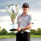 Northern Irish golfer Rory McIlroy poses with the champion's trophy after winning the PGA...