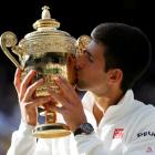 Novak Djokovic kisses the trophy after beating Roger Federer in their men's singles final at...