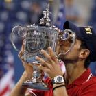 Novak Djokovic of Serbia kisses his trophy after defeating Rafael Nadal of Spain in the men's...