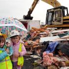 Observing the demolition of Green Island Kindergarten yesterday are Hannah Jones (4, left) and...
