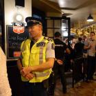 Sergeant Ian Paulin, of  Dunedin, talks to a bar patron in the Octagon on Saturday night. Photos ...