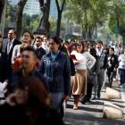 Office workers gather on Paseo de la Reforma avenue in Mexico City after being evacuated from the...
