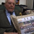 Waimate centenarian Jim Brown with the cushion presented to him by the Waimate Dog Trial Club....