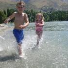 Oliver Leen (7) and his sister Emily (5), of Pauanui, North Island, enjoy playing in Roys Bay,...