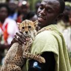 Olympic champion Usain Bolt of Jamaica holds a three-month old male cheetah cub which he named...