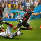 Omar Gonzalez of the US (L) tackles Germany's Thomas Mueller. REUTERS/Tony Gentile