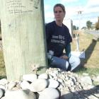 Debbie Devon sits at the site of a car crash at Waitaki Bridge which claimed the lives of her...