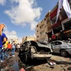 Onlookers take photographs following a car bomb explosion outside a hospital in Benghazi, Libya....