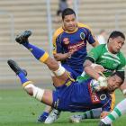 Otago captain Alando Soakai is lowered by Manawatu second five-eighth Johnny Leota at Carisbrook...