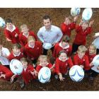 Mike Kerr of the Otago Rugby Football Union with pupils of Fairfield Primary School launching the...