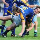 Otago halfback Sean Romans goes to ground in the tackle of his Northland counterpart, Rhyan Caine...
