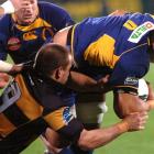 Otago No 8 Steven Setephano, with halfback Toby Morland in support, is tackled by Taranaki...