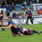 Otago prop Ben Nolan crashes over the line in the tackle of Tasman lock Joseph Wheeler to score...