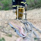 Otago Rural firefighter Daniel Marsh packs up equipment following a large scrub fire near the...