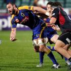 Otago's Hayden Triggs hands off a pass in the tackle of North Harbour's Mike Reid during last...